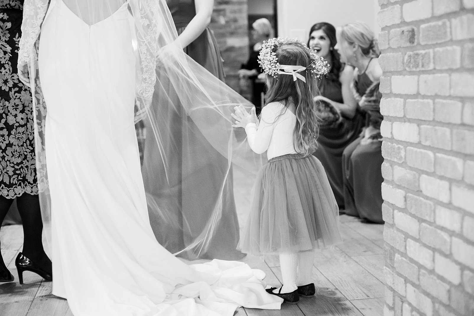 flower girl holding brides veil